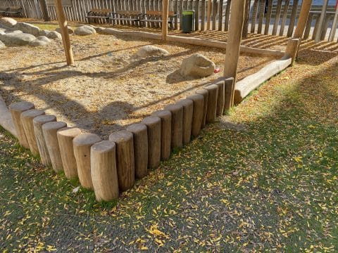Sandmuldeneinfassung mit Holzpergola auf Parkanlage