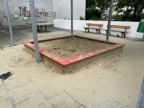 Große Sandkiste mit rotem Sitz Rand auf dem Spielplatz
