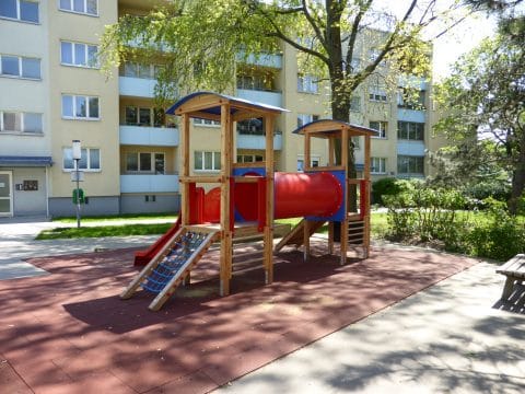 Kinderspielplatz für Wohnhaus mit Doppelturmanlage und roter Röhre