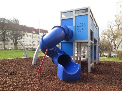 Große blaue Röhrenrutsche am Spielplatz auf Rindenmulch