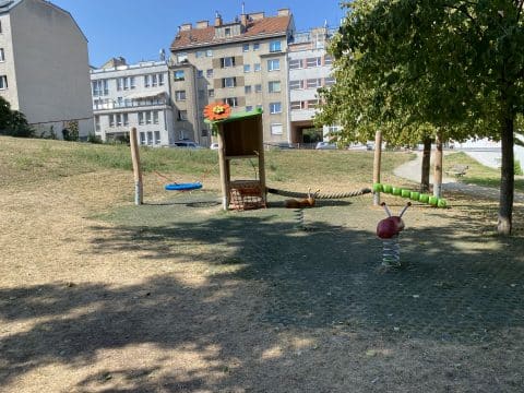 Kinderspielplatz im Park mit Ameisenwippe und Käferwippe auf Wabenmatten als Fallschutz