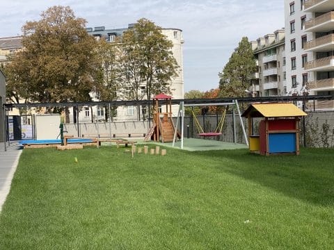 Spielplatz mit Spielturm, Spielhaus und Balancierbalken in Parkanlage