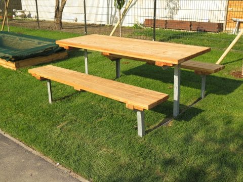 Picknick-Tisch am Spielplatz aus Holz neben Sandkasten