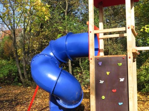 Wendelrutsche in blau mit Spielturm im Wald
