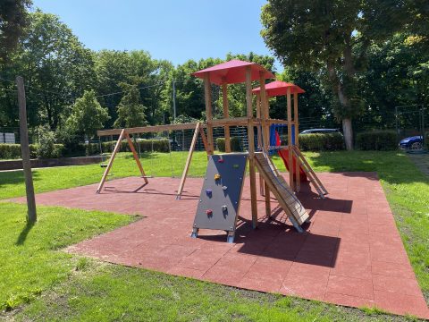Schulgarten mit Kinderspielgerät mit Schaukeln und Kletterwand