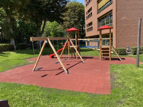 Schulgarten mit Kinderspielgerät auf Fallschutzplatten