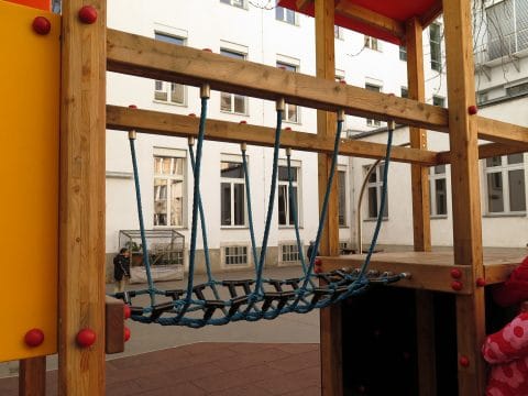 Netzbrücke am Spielturm aus Holz im Kindergarten