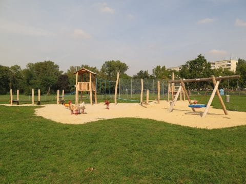 Spielplatz aus Naturholz mit Schaukel und Spielturm