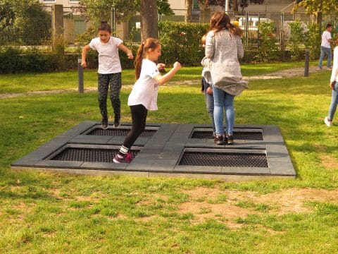 Bodentrampolin mit spielenden Kindern auf dem Spielplatz