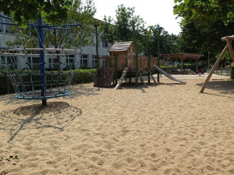 Spielplatz mit Spielhaus und Kletterpyramide auf gereinigten Sand