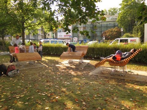 Sit&Move Wave von FREISPIEL Holzliegen im Park auf Federn