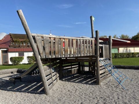 Spielplatz mit Piratenschiff im Sandkasten mit Kletternetz und Rutsche