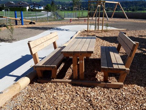 Tischbankkombination aus Lärchenholz mit Lehne neben dem Spielplatz