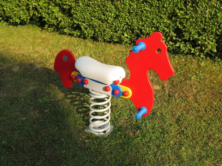 Wippe in Pferdeform auf Feder auf der Wiese