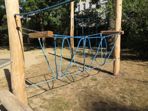 Dreiseilbrücke zwischen zwei Holzbalken montiert im Park