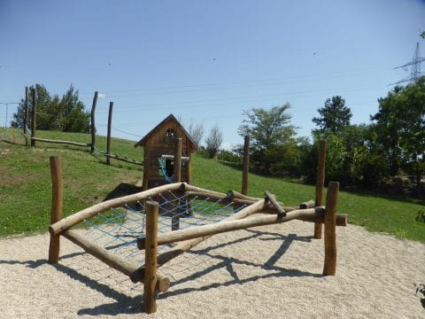 Kletterpark mit Holzhäuschen am Hang für Kinder