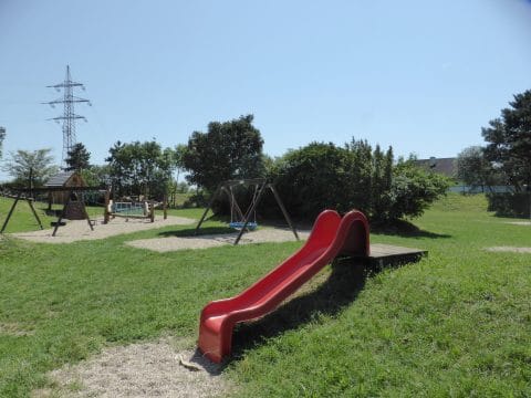Rote Hangrutsche auf Rutschpodest am Spielplatz