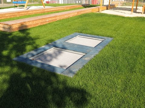 Bodentrampolin im wunderschönen Rasen mit Fallschutzplatten