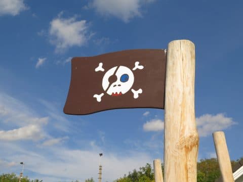 Detail Piratenschild am Holzstamm auf dem Spielplatz
