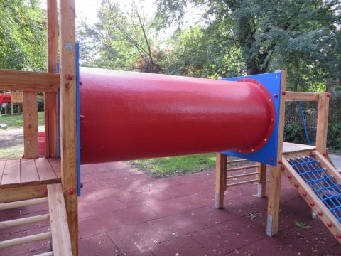 Röhrenverbindung für den Spielturm auf rotem Fallschutz