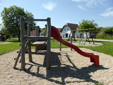 Kinderspielplatz aus Naturholz mit Sprossenaufstieg und Rutsche