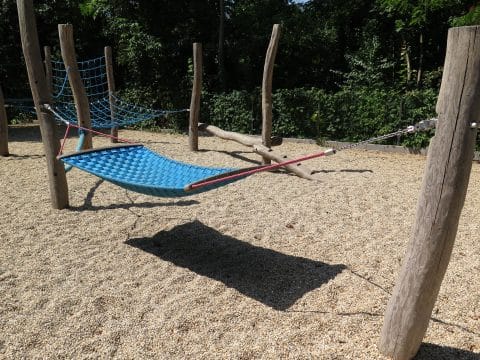 Hängematte aus Seilgeflecht an Holzbalken im Kindergarten zum ausruhen
