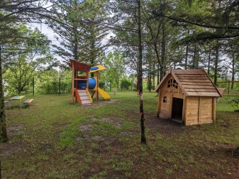 Waldspielplatz mit Holzhaus und Spielturm im Wald