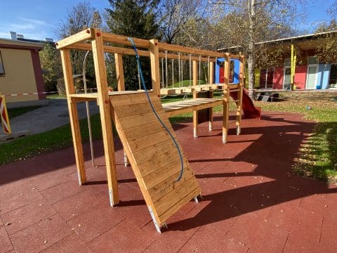 Doppelturmanlage mit Holzsprossenleitern und Rampe im Kindergarten