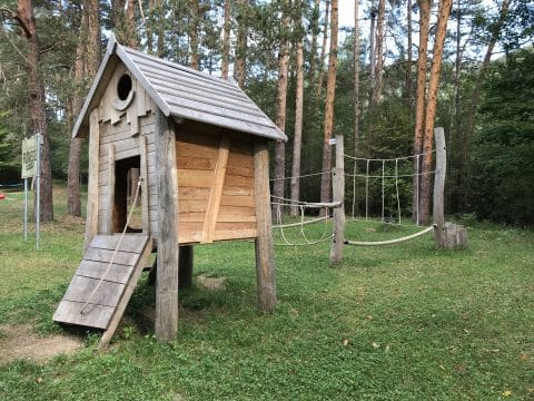 Spielhaus mit Kletterdschungel im Wald für die Kinder