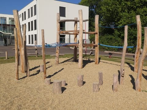 Hüpfpalisaden aus Naturholz am Kletterpark in der Schule