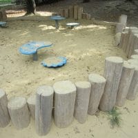 Sandmuldeneinfassung aus Holzpalisaden für Kinder