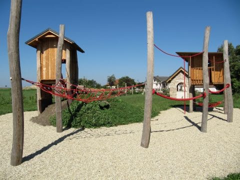 Öffentlicher Spielplatz mit Kletterdschungel zwischen den Holzhäusern