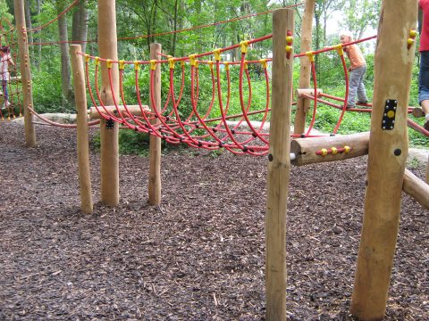 Netzbrücke zwischen den Holzstehern zum balancieren für die Kinder