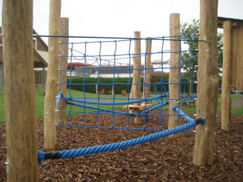 Spielgeräte aus Seilen und Holz auf Rindenmulch im Kindergarten