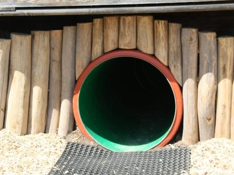 Eingang vom Spielplatztunnel mit Holz verkleidet