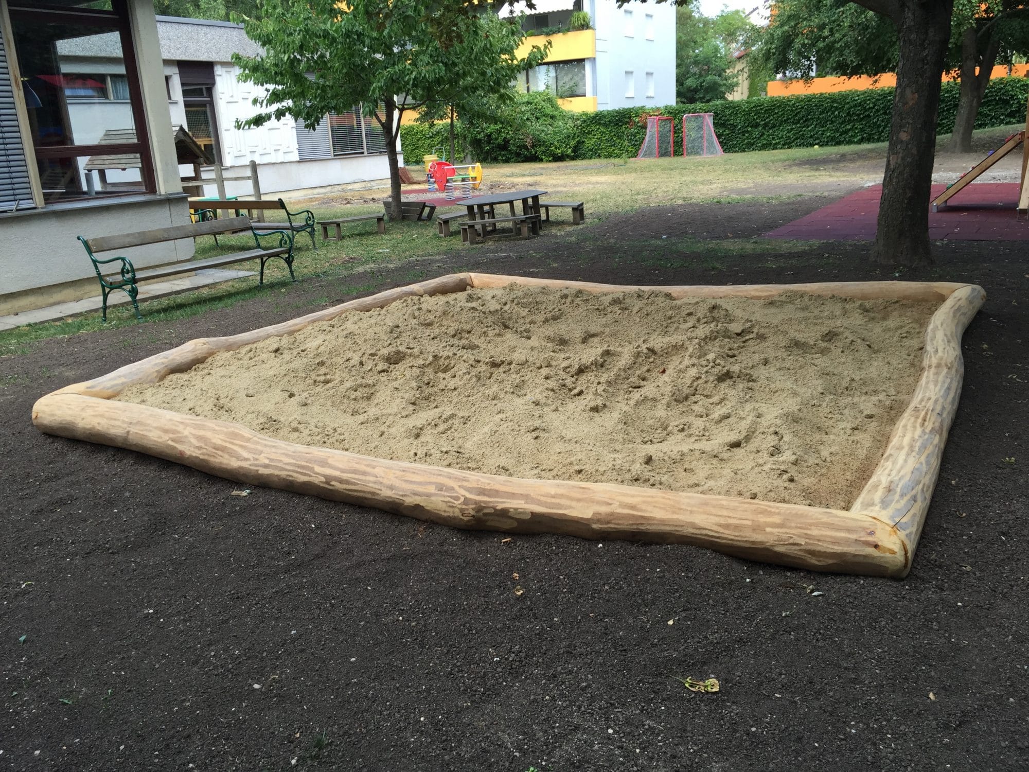 Sandmuldeneinfassung aus Rohholz im Kindergarten kaufen