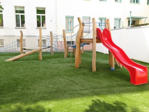 Holz-Spielplatz auf Kunstrasen zum rutschen und balancieren