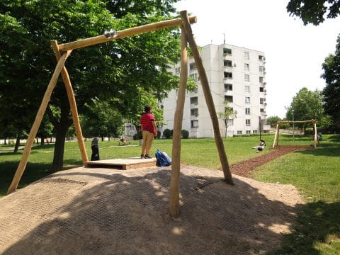 Kinder spielen bei einer Seilbahn im Park