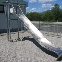 Edelstahlrutsche an Kletterturm mit Sprossenleiter auf dem Spielplatz