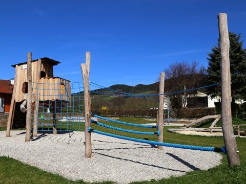 Kletterparcour am Kinderspielplatz mit blauen Seilen und Baumhaus