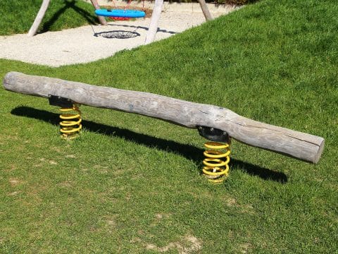 Spielplatz Baumstamm-Wippe auf gelben Federn montiert