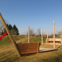 Sandspielschiff Hafenkutter aus Holz auf Kinderspielplatz