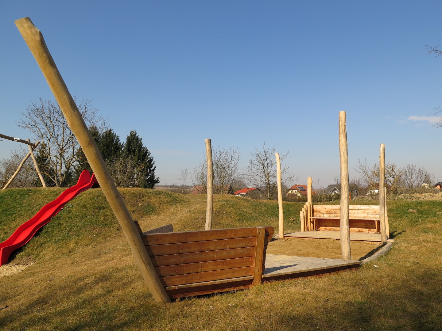 Sandspielschiff Hafenkutter aus Holz auf Kinderspielplatz