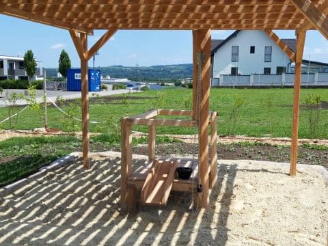Sandspielplatz im Park mit Holzpergola als Sonnenschutz für Kinder