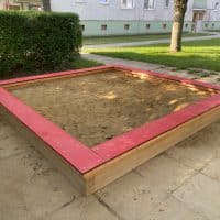 Sandkiste mit roter HDPE Sitzauflage im Park für Kinder kaufen