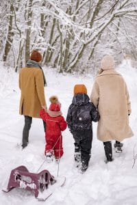 Familie geht durch verschneiten Wald
