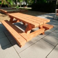 Picknicktisch für Kinder aus Holz vor einem Spielplatz